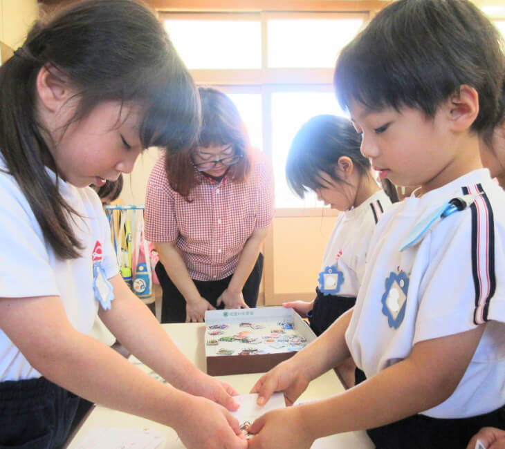 園児同士がごっこ遊びではがきを手渡している