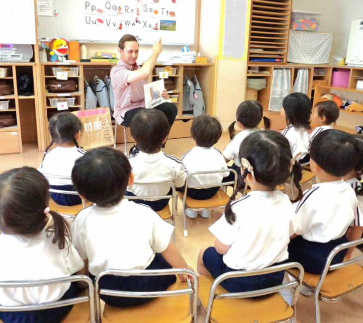 園児たち英語の授業を座って受けている