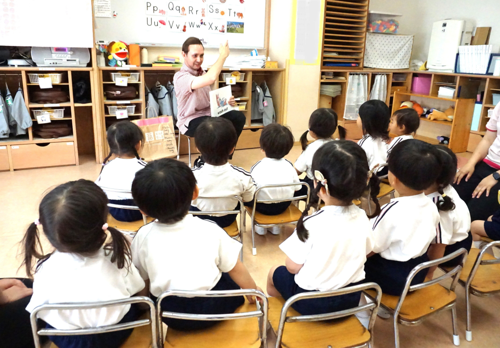園児たち英語の授業を座って受けている