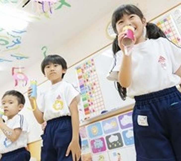 園児が工作のマイクで遊ぶ様子