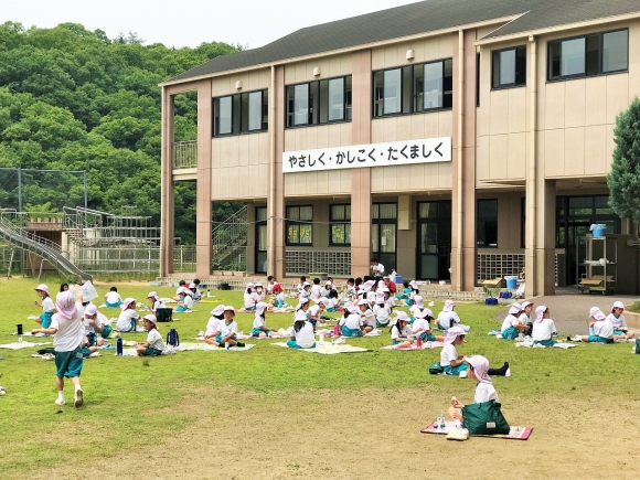 運動場で弁当給食を食べました