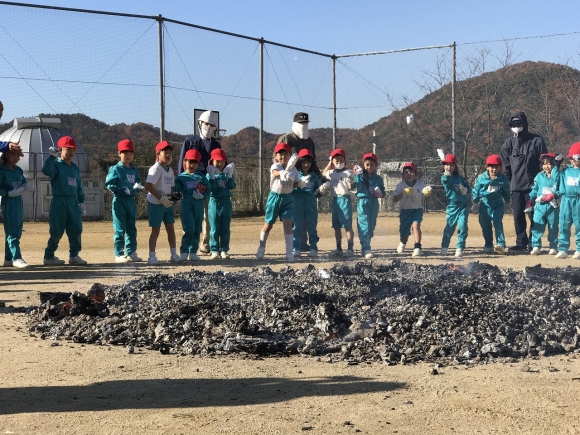 おいしくなあれ！いもを炭に投げ入れます。