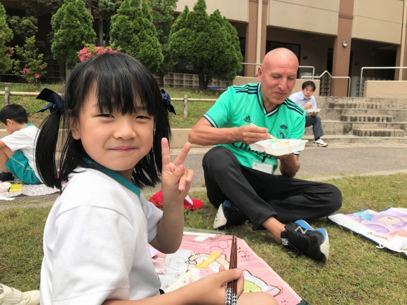 運動場で弁当給食を食べました