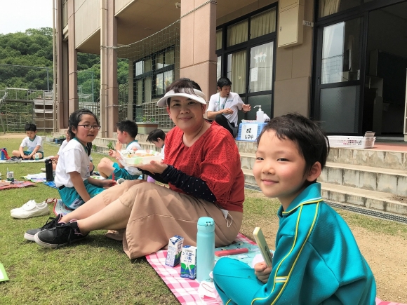 運動場で弁当給食を食べました