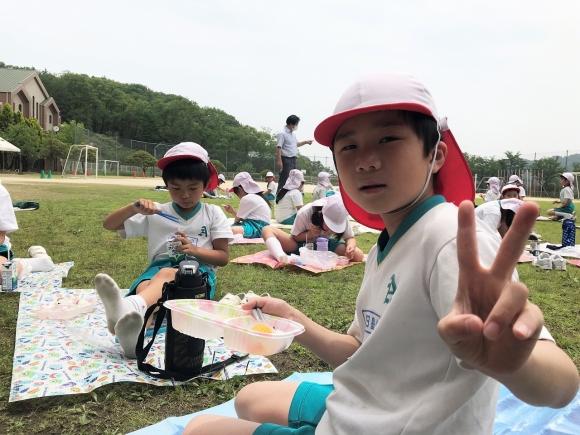 運動場で弁当給食を食べました